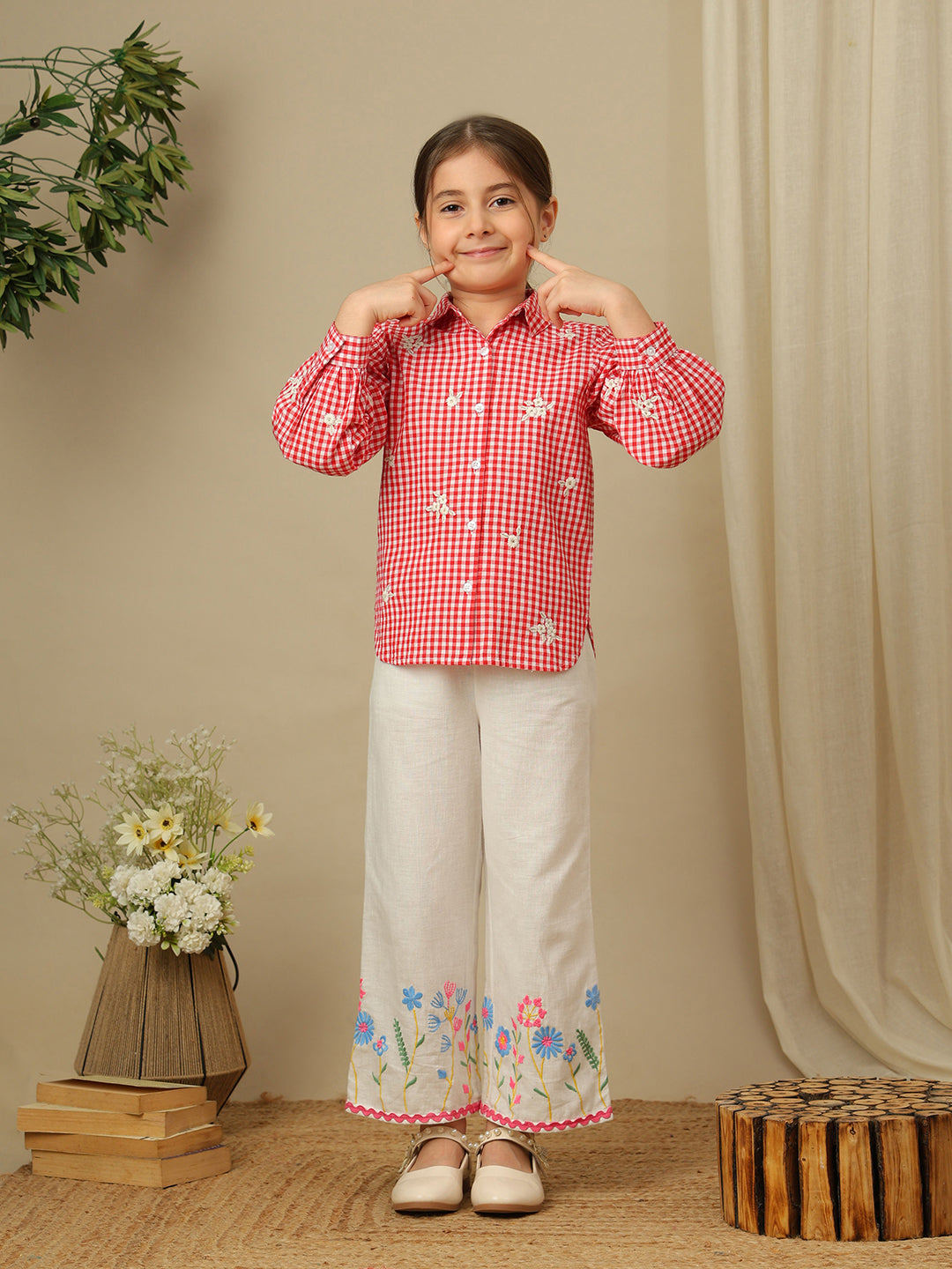 Girls red and white checked cotton shirt with floral embroidery, collared neck, button-down front and full puff sleeves.