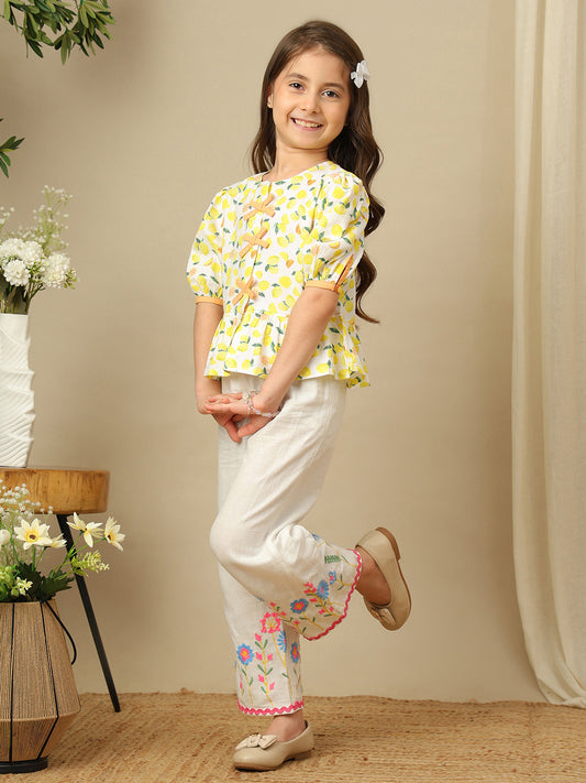 Girls lemon print cotton top with puff sleeves, contrast bow detailing and gathered peplum hem.