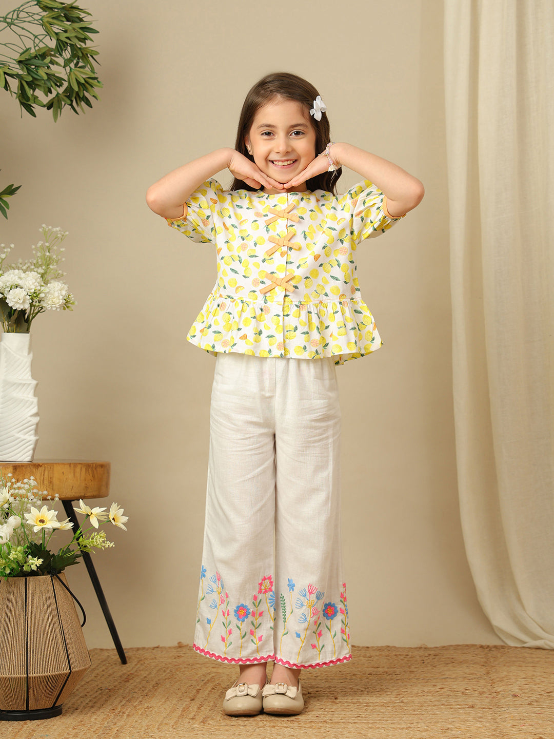 Girls lemon print cotton top with puff sleeves, contrast bow detailing and gathered peplum hem.