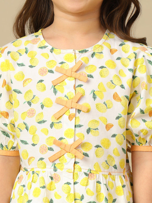 Girls lemon print cotton top with puff sleeves, contrast bow detailing and gathered peplum hem.