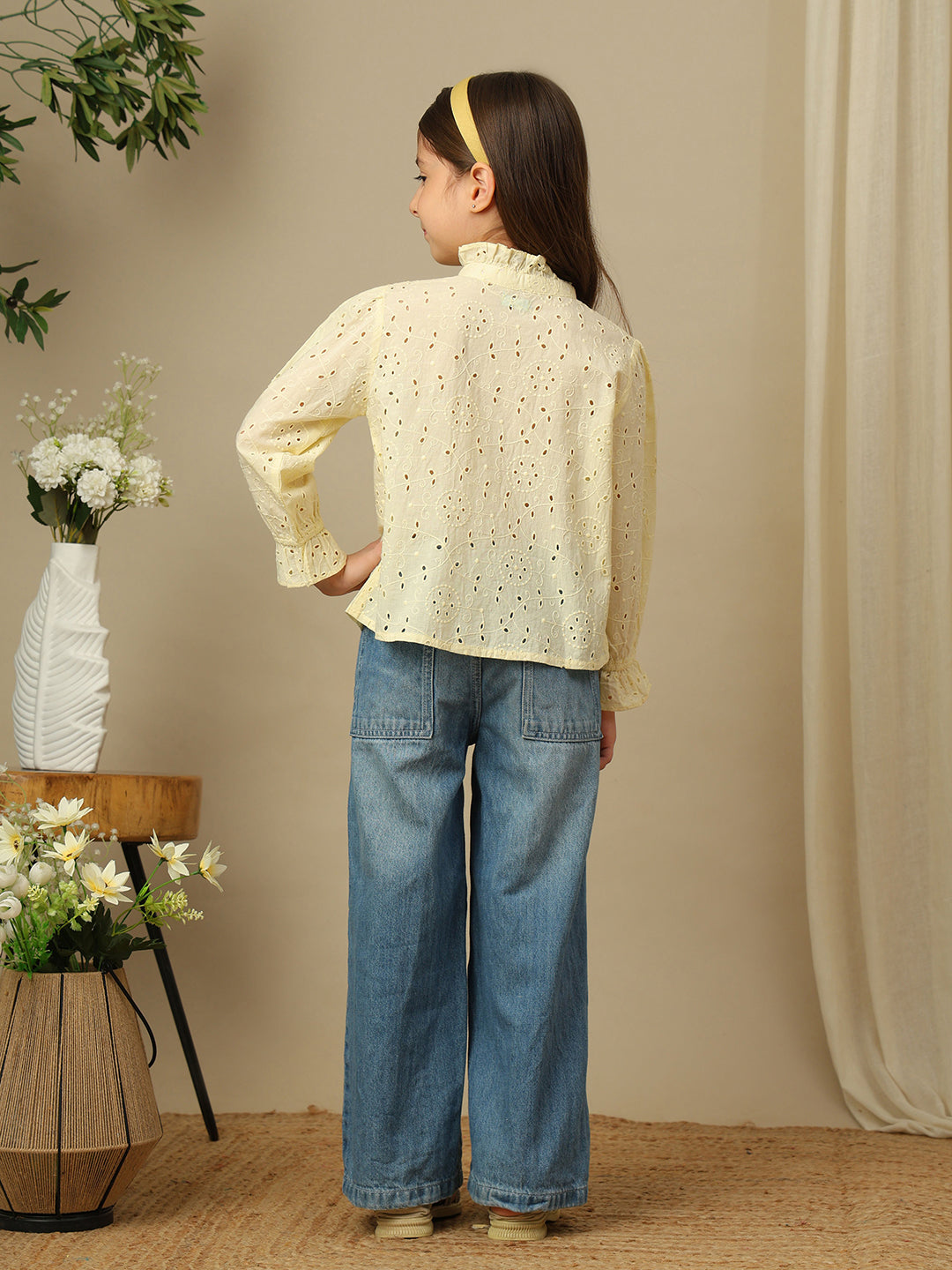 Girls yellow cotton Schiffli shirt with all-over eyelet embroidery, ruffled high neckline, button front and long sleeves.