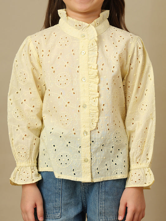 Girls yellow cotton Schiffli shirt with all-over eyelet embroidery, ruffled high neckline, button front and long sleeves.