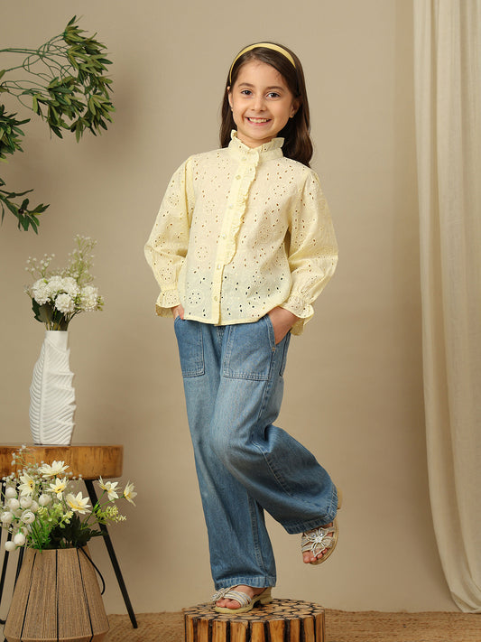 Girls yellow cotton Schiffli shirt with all-over eyelet embroidery, ruffled high neckline, button front and long sleeves.