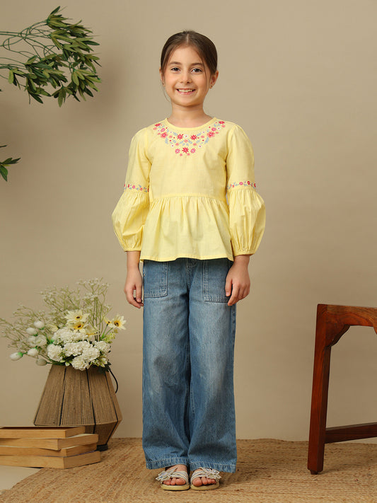 Girls yellow cotton peplum top with multicolour floral embroidery, round neckline and three-quarter balloon sleeves.