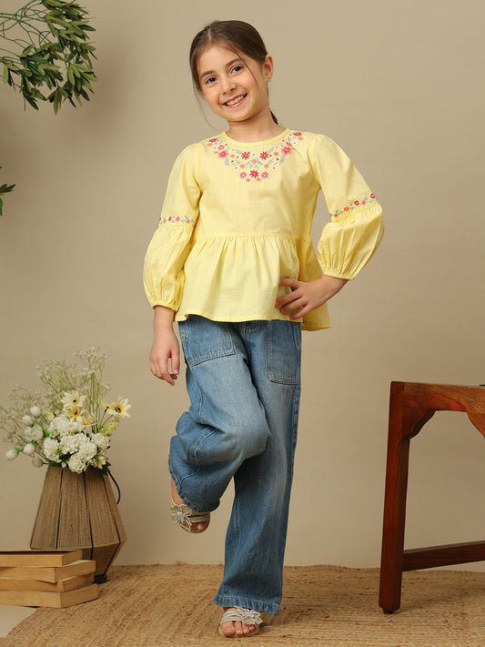 Girls yellow cotton peplum top with multicolour floral embroidery, round neckline and three-quarter balloon sleeves.