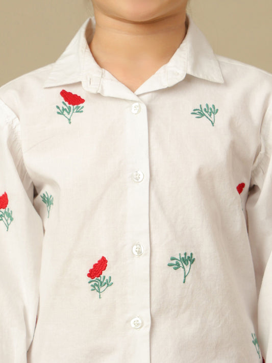 Girls white cotton shirt with red floral embroidery, green leaf detailing, collared neck, button-down front and full sleeves.