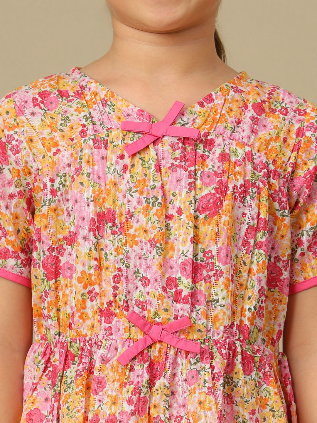 Girls floral print cotton top with bow detailing, short sleeves, pintucks and gathered peplum hem.