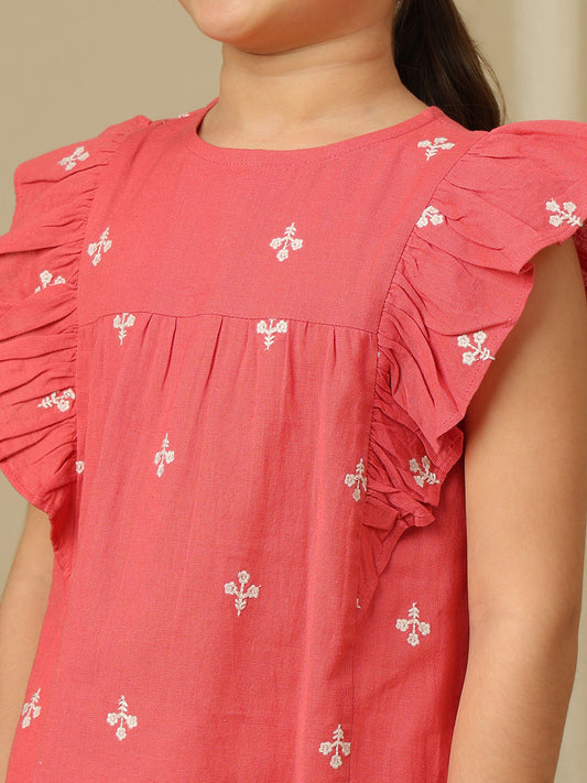 Girls coral cotton top with white floral embroidery, gathered yoke and layered ruffle sleeves.