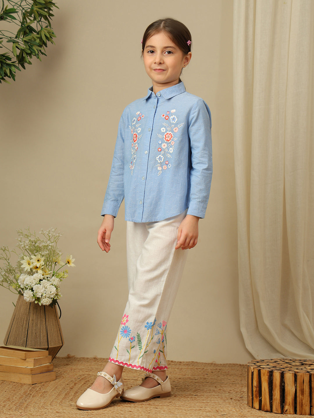 Girls blue cotton shirt with multicolour floral embroidery, classic collar, button-down front and full sleeves.