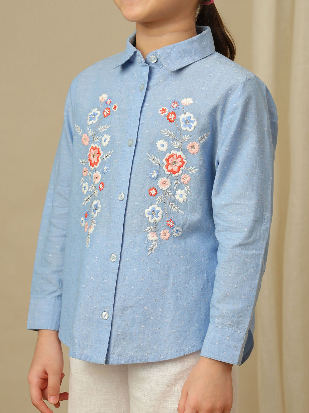 Girls blue cotton shirt with multicolour floral embroidery, classic collar, button-down front and full sleeves.