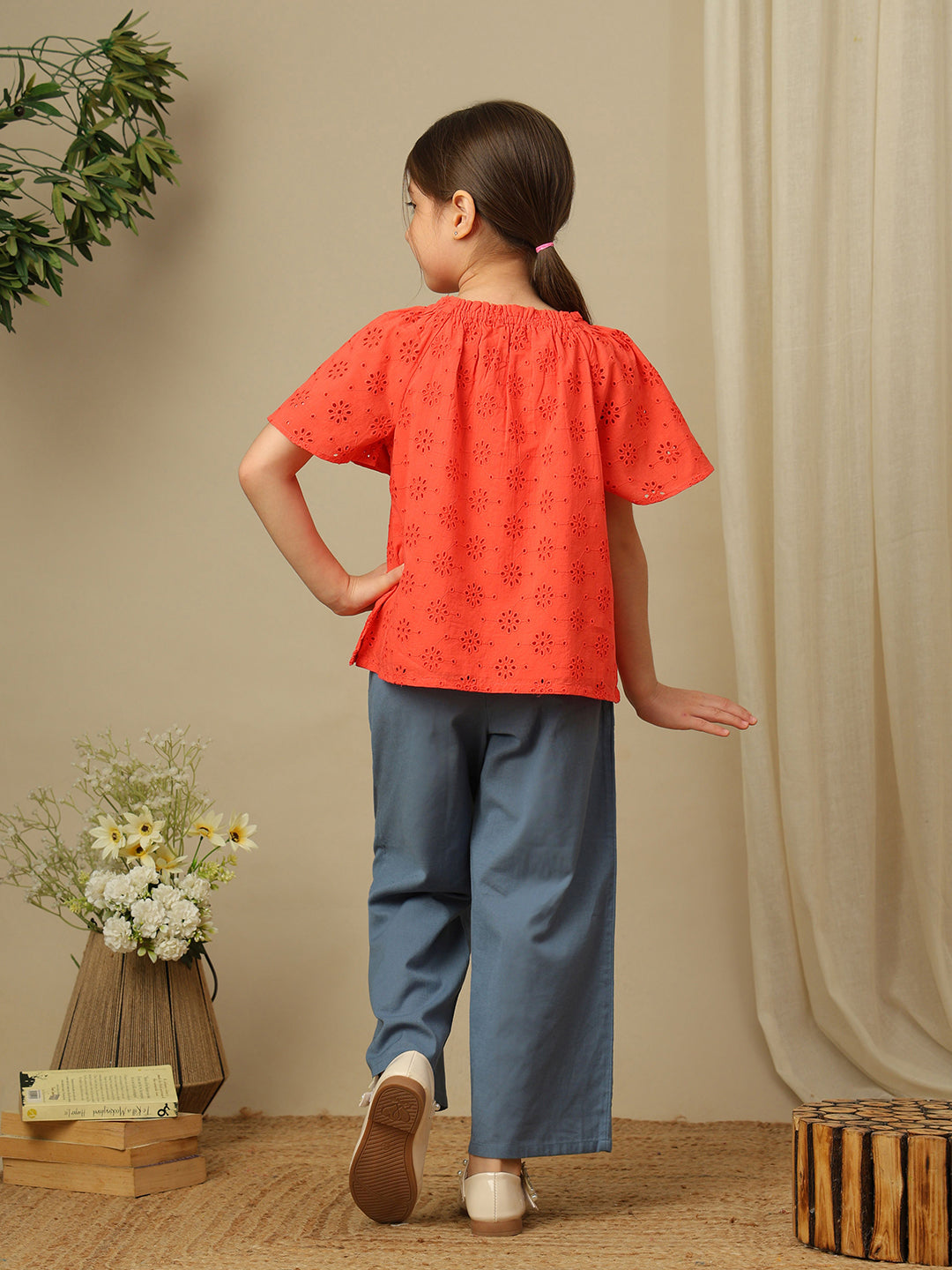 Girls cotton top with floral eyelet embroidery, gathered neckline and flutter sleeves.