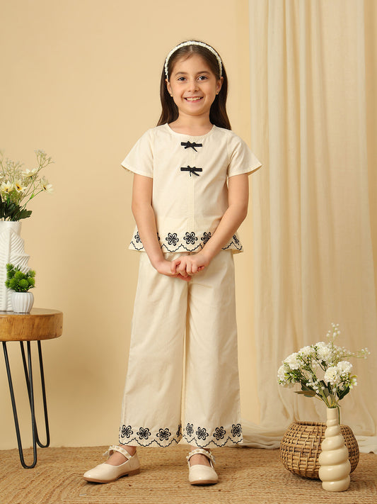 Girls off-white cotton co-ord set with black bow detailing and floral embroidered scalloped hems