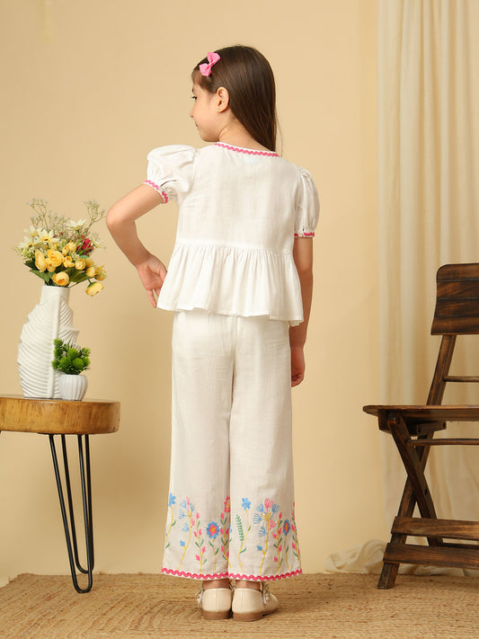 Girls off-white cotton co-ord set with floral embroidered peplum top, puff sleeves and matching wide-leg pants with colorful floral embroidery.