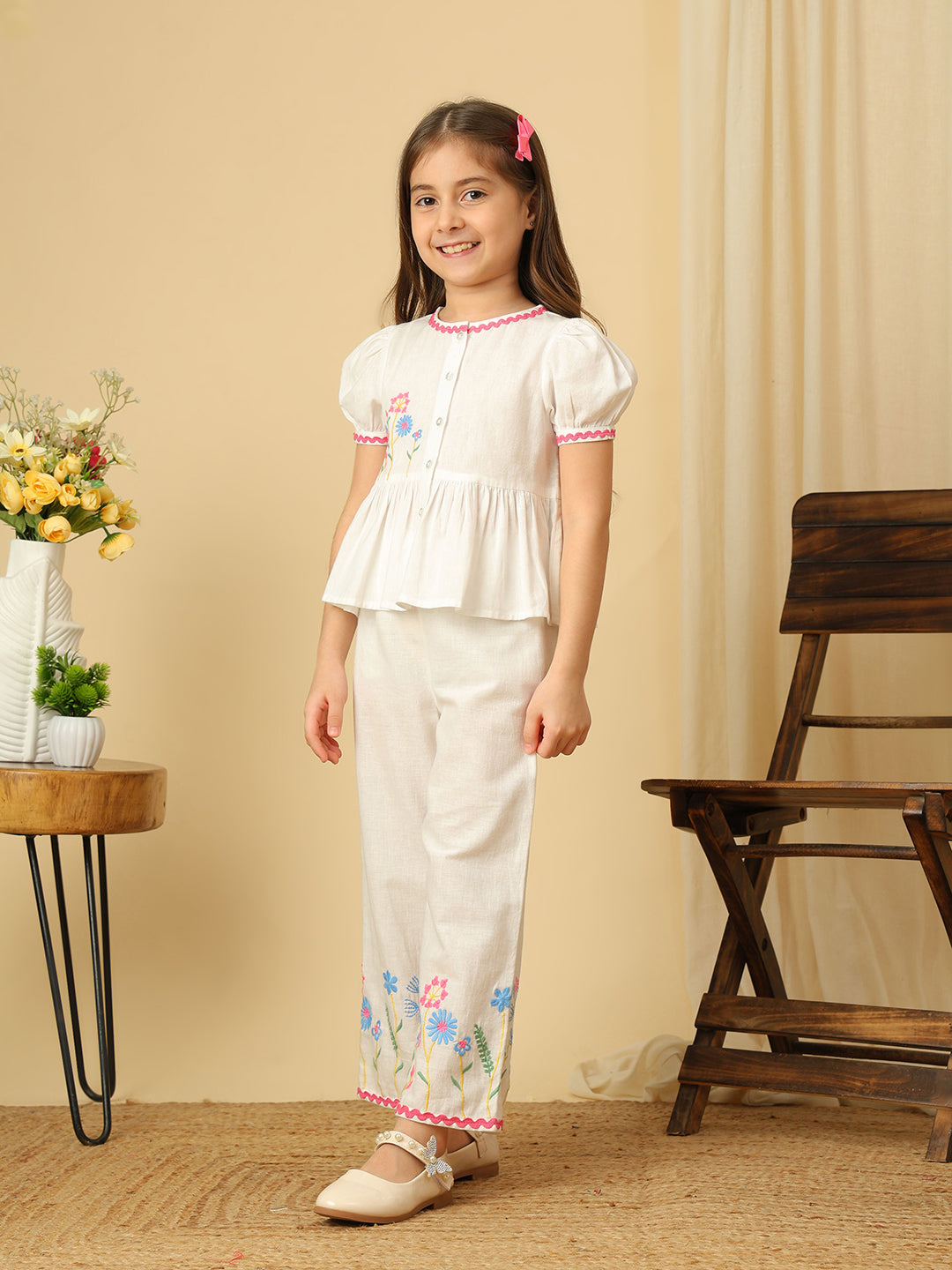 Girls off-white cotton co-ord set with floral embroidered peplum top, puff sleeves and matching wide-leg pants with colorful floral embroidery.