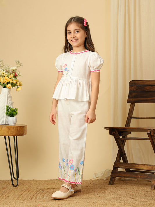 Girls off-white cotton co-ord set with floral embroidered peplum top, puff sleeves and matching wide-leg pants with colorful floral embroidery.