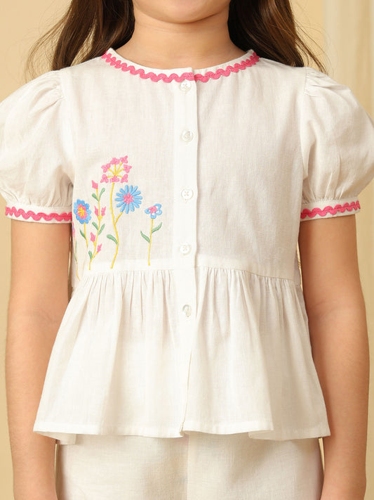 Girls off-white cotton co-ord set with floral embroidered peplum top, puff sleeves and matching wide-leg pants with colorful floral embroidery.