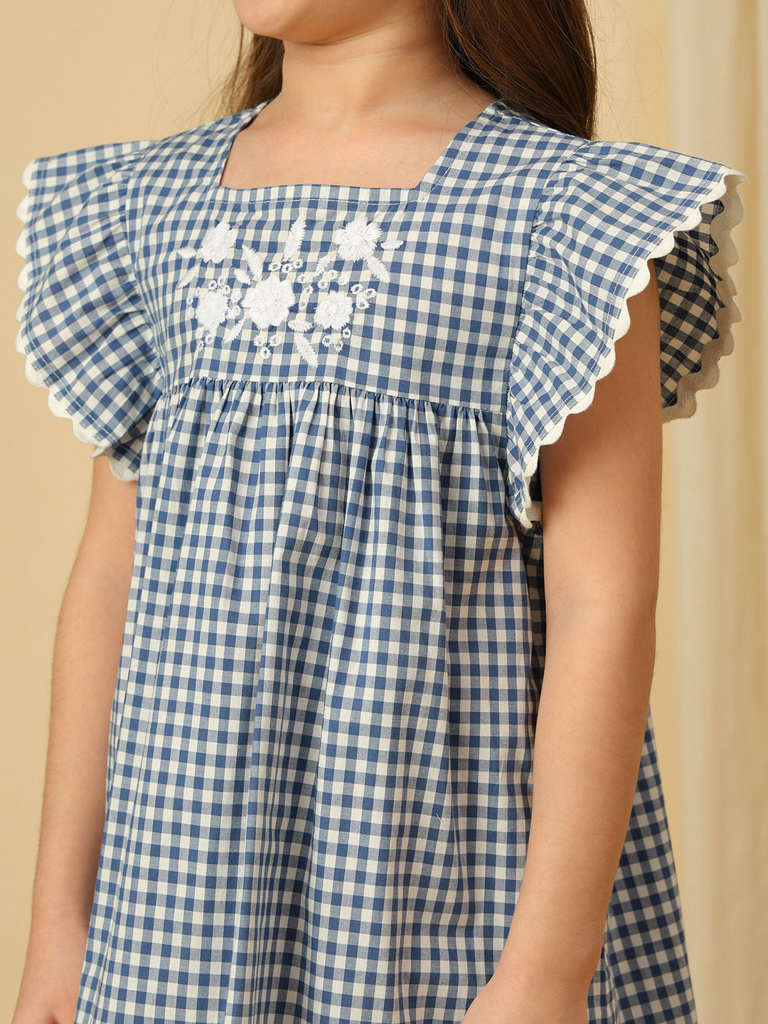 Girls blue gingham check dress with white floral embroidery, square neckline and flutter sleeves